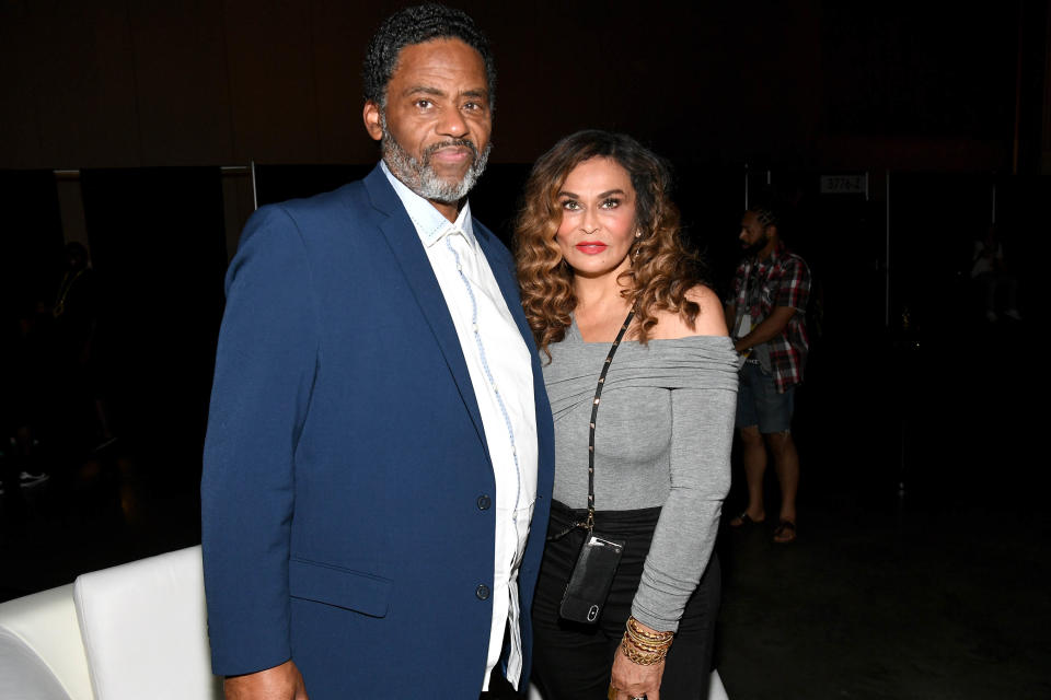 Richard Lawson in a blue suit and Tina Knowles Lawson in a grey shirt and black pants pose for a photo. (Paras Griffin / Getty Images file)