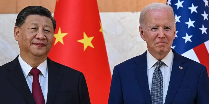 China President Xi Jinping and US President Joe Biden in front of flags.