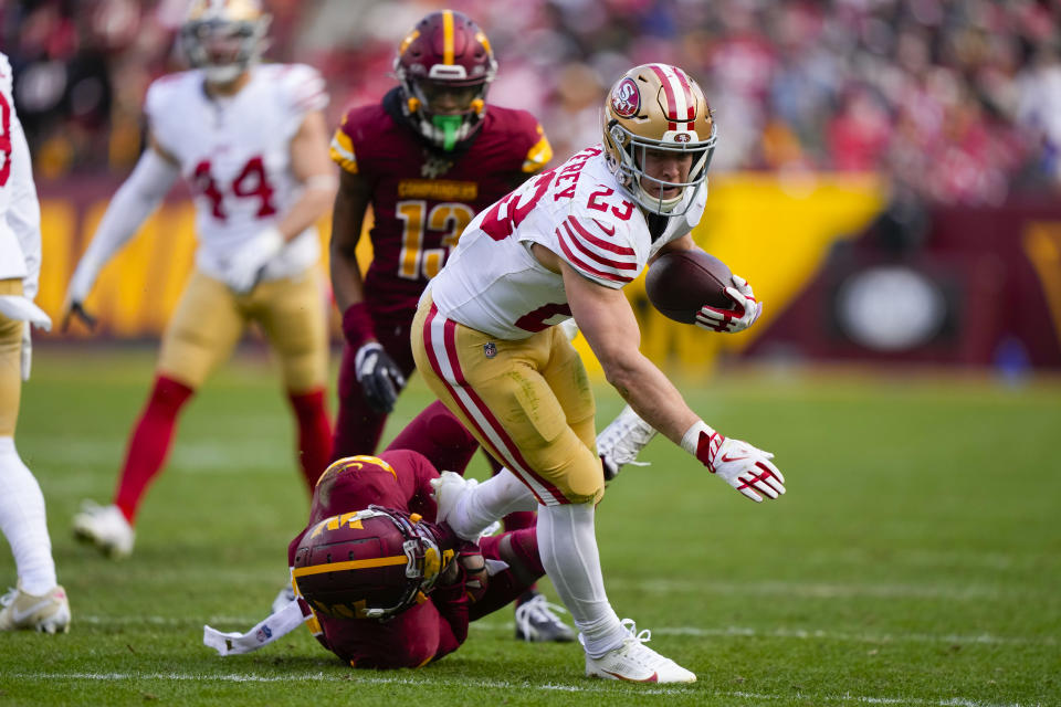 San Francisco 49ers running back Christian McCaffrey (23) is tackled by Washington Commanders safety Kamren Curl (31) during the first half of an NFL football game, Sunday, Dec. 31, 2023, in Landover, Md. (AP Photo/Mark Schiefelbein)