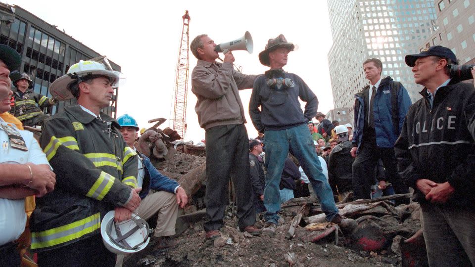 Bush stands atop a crumpled fire truck with retired New York City fireman Bob Beckwith on September 14, 2001. - Eric Draper/The White House/National Archives