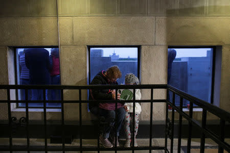 A woman reads a book to a girl during the Night of Open Books event inside Bucharest's Arch of Triumph in Bucharest, Romania, April 23, 2019. Picture taken April 23, 2019. Inquam Photos/Octav Ganea via REUTERS