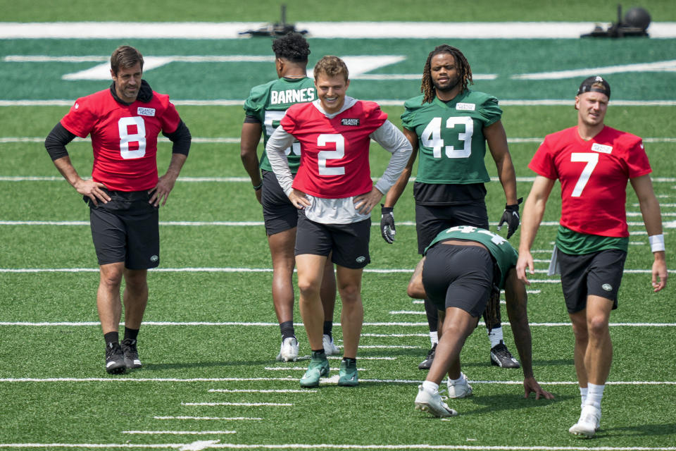 CORRECTS CITY AND STATE - New York Jets quarterback Aaron Rodgers (8) performs stretching drills with quarterbacks Zach Wilson (2) and Tim Boyle (7) at the NFL football team's practice facility, Tuesday, May 23, 2023, in Florham Park, N.J. (AP Photo/John Minchillo)