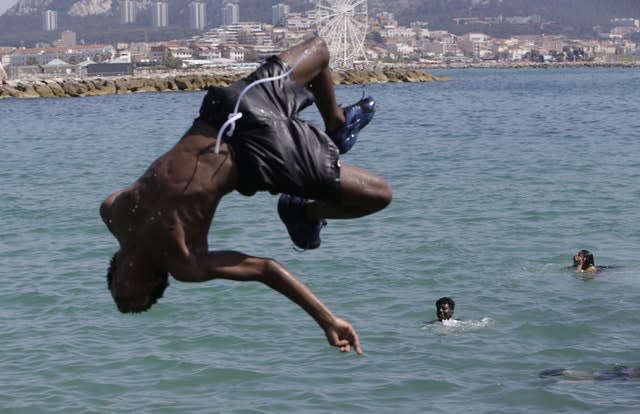 A boy jumps into the Mediterranean Sea in Marseille, southern France. France and other nations battle a record-setting heat wave baking much of Europe. The French national weather service activated its highest-level heat danger alert for the first time, putting four regions around Marseille and Montpellier in the south of the country under special watch Friday