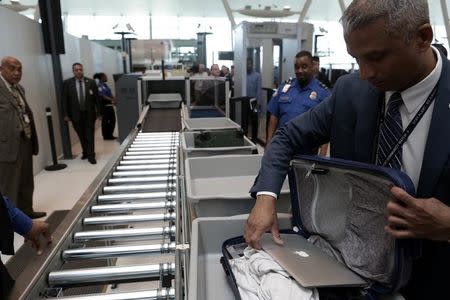 A TSA official removes a laptop from a bag for scanning using the Transport Security Administration's new Automated Screening Lane technology at Terminal 4 of JFK airport in New York City, U.S., May 17, 2017. REUTERS/Joe Penney/Files