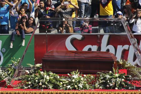 People react as the coffin with the remains of the late screenwriter Roberto Gomez Bolanos passes by upon arriving for a mass held in his honour at the Azteca stadium in Mexico City November 30, 2014. REUTERS/Tomas Bravo