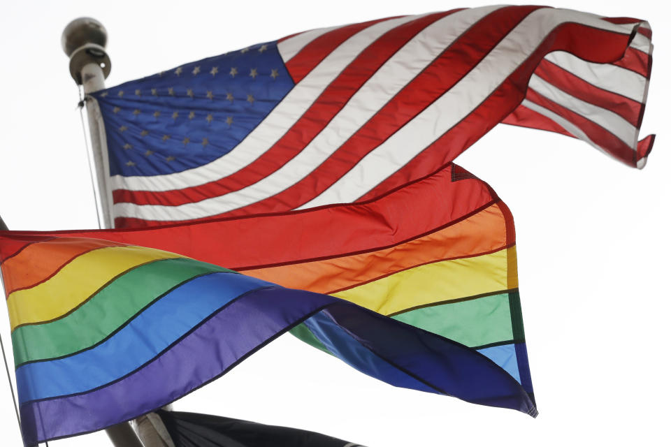 The Rainbow Flag, an international symbol of LGBT liberation and pride, flies beneath the American flag at the Stonewall National Monument on Oct. 11, 2017, in New York. “All men are created equal.” Few words in American history are invoked as often as the preamble to the Declaration of Independence, published nearly 250 years ago, and few more difficult to define. (AP Photo/Mark Lennihan, File)
