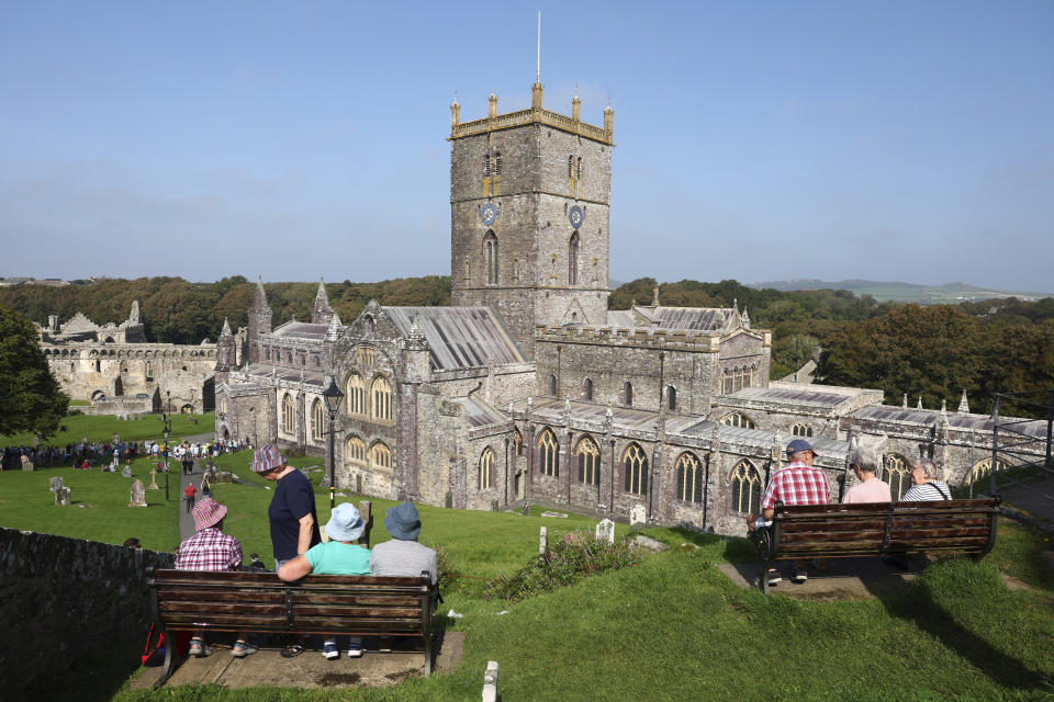 People wait for the arrival of Britain's Prince William, and Kate, Princess of Wales, outside St Davids Cathedral, on the first anniversary of Queen Elizabeth's death, in St. Davids, Wales, Britain, Friday, Sept. 8, 2023. (Toby Melville/Pool Photo via AP)