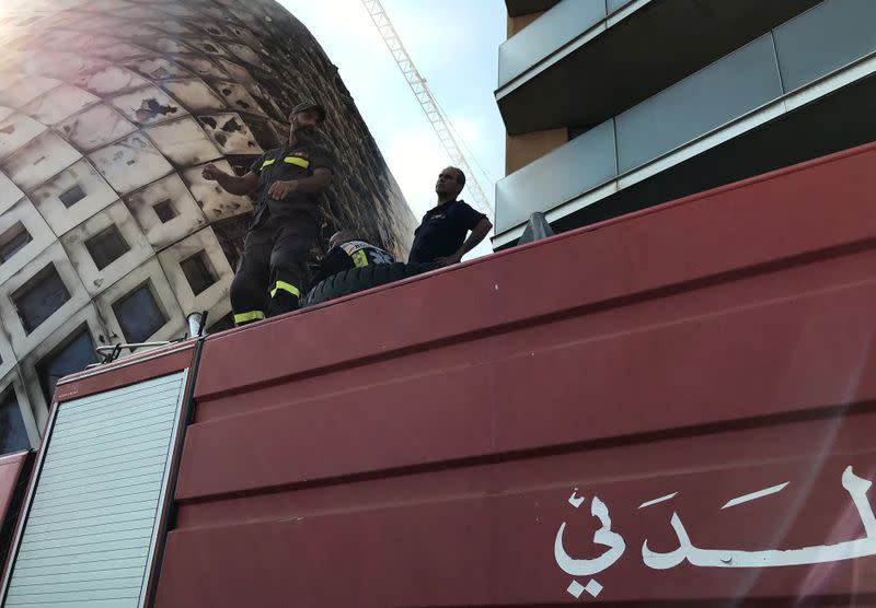 Civil defence members participate in efforts to put out a fire that broke out in a building in Central Beirut