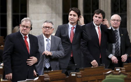 Liberal leader Justin Trudeau (C) stands to vote in the House of Commons on Parliament Hill in Ottawa March 30, 2015. REUTERS/Chris Wattie