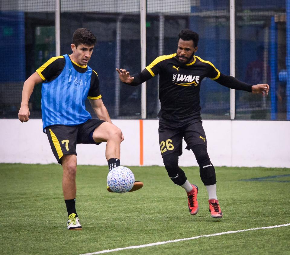 Daniel Mattos passes in front of Ian Bennett  during Milwaukee Wave practice at the Brookfield Sports Complex.
