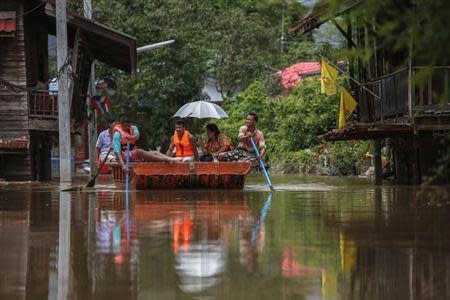 People paddle as they travel along a flooded street by boat at Kabin Buri district in Prachin Buri September 29, 2013. REUTERS/Athit Perawongmetha