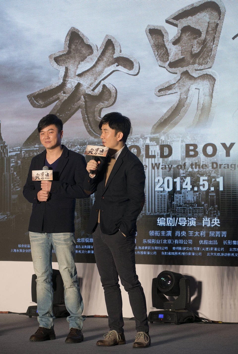 Chinese actor Wang Taili, right, speaks next to film director and actor Xiao Yang on stage as they promote their new movie “Old Boys: The Way of the Dragon” in Beijing Thursday, Jan. 9, 2014. An online microfilm that was watched by millions and helped to establish a genre in China is to be made into a feature-length movie and shown in the country’s cinemas. The planned debut of “Old Boys” in China’s cinemas in May after ratcheting up almost 70 million views on a video website demonstrates how online films are influencing the traditional film industry. (AP Photo/Andy Wong)