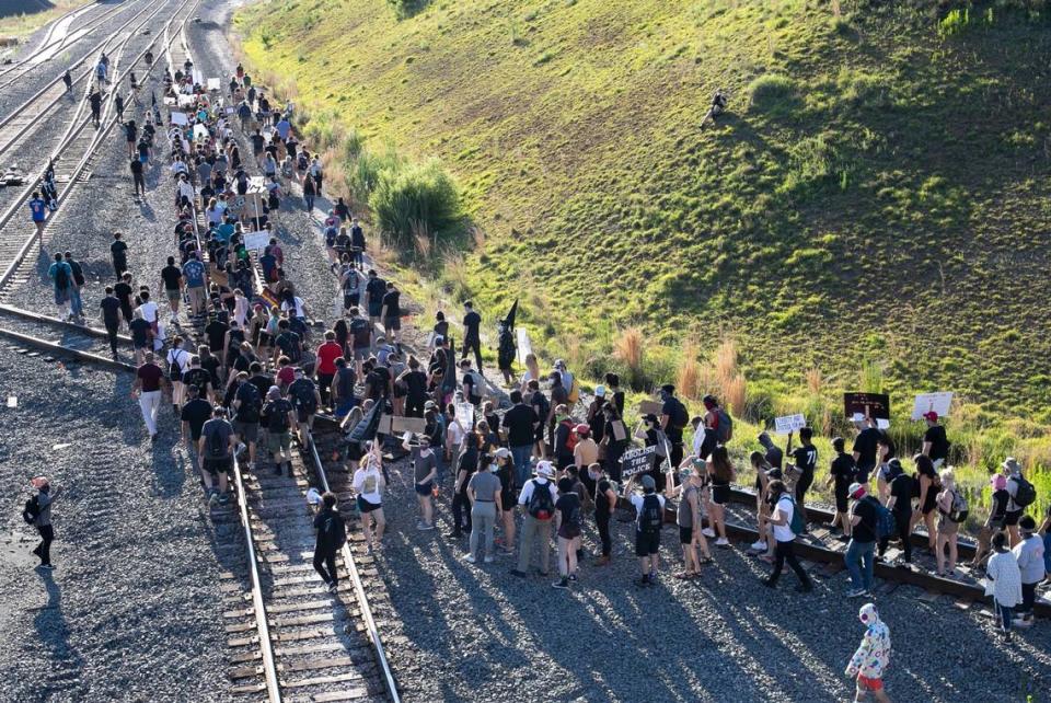 Protesters march along the railroad tracks beneath the Boylan Avenue Bridge to Central Prison for a rally on police and orison reform on Saturday, June 13, 2020 in Raleigh, N.C.