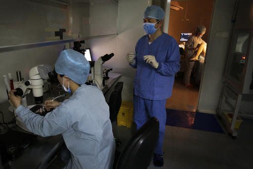 In this Sunday, April 24, 2016 photo, Dr. Liu Jiaen, center, watches his staff member work on a laboratory dish during an infertility treatment through in vitro fertilization (IVF) for a patient at a hospital in Beijing. China’s decision to allow all married couples to have two children is driving a surge in demand for fertility treatment among older women, putting heavy pressure on clinics and breaking down past sensitivities, and even shame, about the issue. The rise in IVF points to the deferred dreams of many parents who long wanted a second child, but were prevented by a strict population control policy in place for more than 30 years. (AP Photo/Andy Wong)