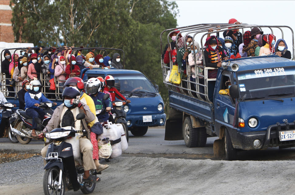 Garment workers stand on the trucks as they head to work outside Phnom Penh, Cambodia, Thursday, May 6, 2021. Cambodia on Thursday ended a lockdown in the capital region. (AP Photo/Heng Sinith)