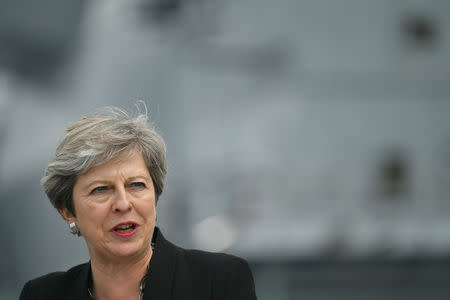 Britain's Prime Minister Theresa May stands on the flight deck as she speaks to crew members of the British aircraft carrier HMS Queen Elizabeth, during her tour of the ship, after it arrived at Portsmouth Naval base, its new home port, in Portsmouth, Britain August 16, 2017. REUTERS/Ben Stansall/Pool