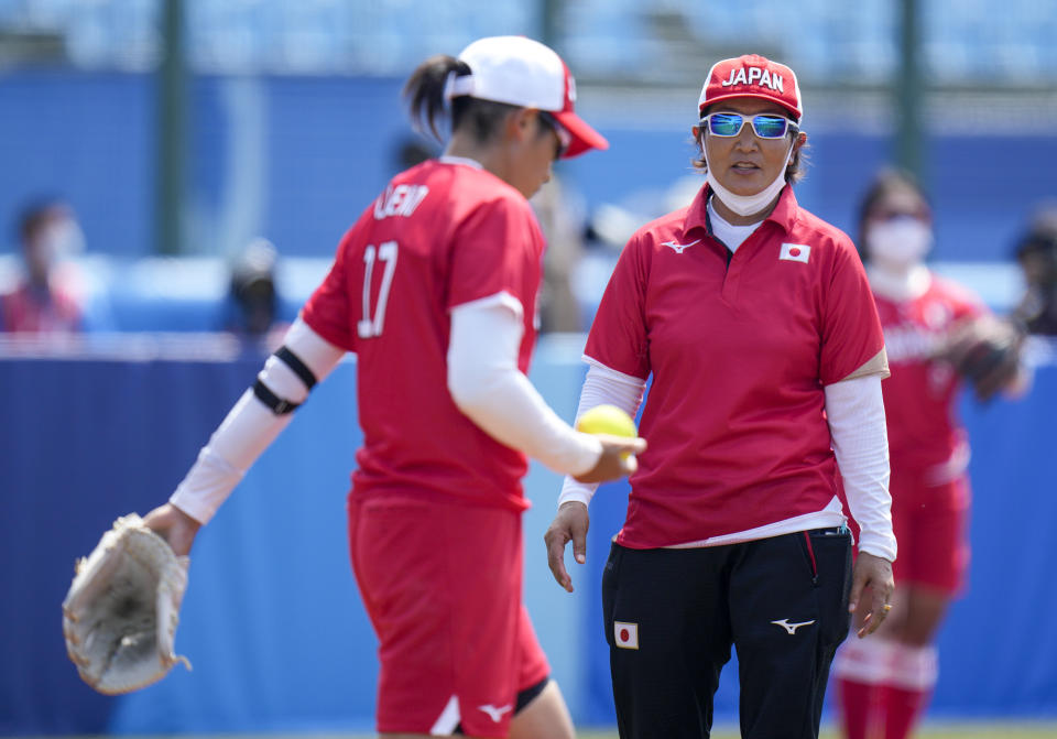 Japan head coach Reika Utsugi talks to player Yukiko Ueno during the softball game between Japan and Australia at the 2020 Summer Olympics, Wednesday, July 21, 2021, in Fukushima . (AP Photo/Jae C. Hong)