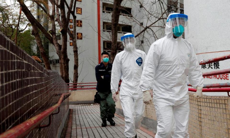 Health workers in protective gears evacuate residents from a public housing building in Hong Kong