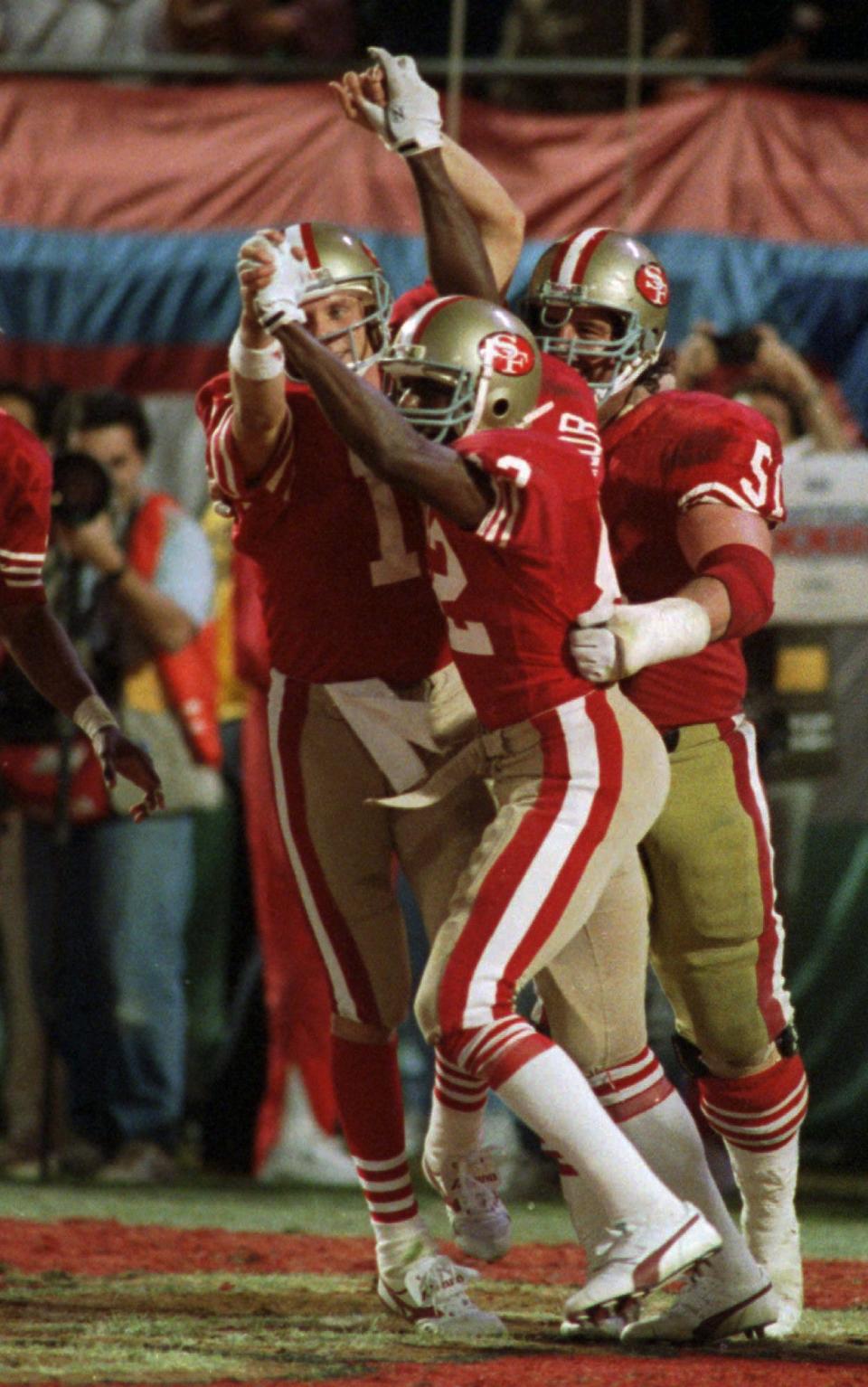 San Francisco 49ers quarterback Joe Montana (16) and wide receiver John Taylor (82) clasp hands after Montana's pass to Taylor at the end of the fourth quarter resulted in a 20-16 victory over the Cincinnati Bengals at Super Bowl XXIII Jan.22, 1989 in Miami.