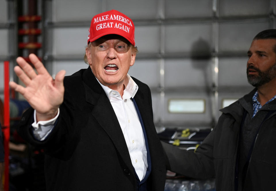 Former President Donald Trump, wearing a Make America Great Again hat, and his son Donald Trump Jr. 