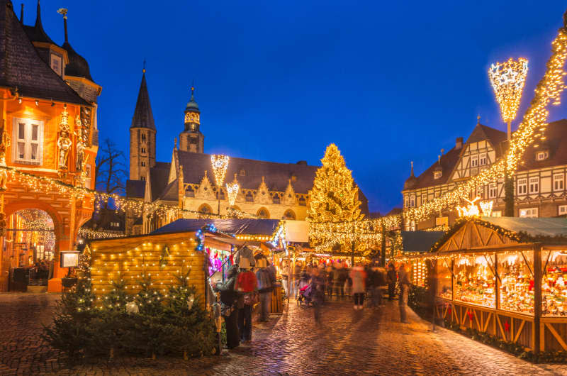 The traditional Christmas Market on the historic Market Square of Goslar, Germany at dusk.