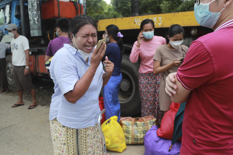 A woman talks to her family members on a phone after she was released from the Insein Prison Tuesday, Oct. 19, 2021, in Yangon, Myanmar. Myanmar's government on Monday announced an amnesty for thousands of prisoners arrested for taking part in anti-government activities following February's seizure of power by the military. (AP Photo)