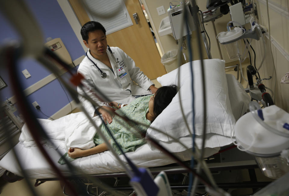 Patient Analy Navarro speaks with Doctor Leon Yeh in the Emergency Room at OSF Saint Francis Medical Center in Peoria, Illinois, November 26, 2013. Now, patients are at the forefront of an experiment, under way in Peoria, Illinois, and hundreds of other U.S. cities, that could transform the way doctors, nurses and hospitals deliver care to patients. Amid the barrage of criticism over the rollout of Obamacare, groups known as Accountable Care Organizations (ACOs) are quietly going about the business of testing the potential for healthcare reform. The efforts, born of President Barack Obama's Affordable Care Act, are part of the biggest experiment yet to fix the costly and error-plagued U.S. healthcare system. The new models of care, which encourage providers to form networks to coordinate care and cut costs, involve close monitoring of the sickest patients to address budding health problems before they cause a costly trip to the emergency room or an extended hospital stay. To match Feature USA-HEALTHCARE/PEORIA Picture taken November 26, 2013. REUTERS/Jim Young  (UNITED STATES - Tags: HEALTH POLITICS)