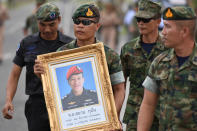 <p>An honor guard holds up a picture of Samarn Poonan, 38, a former member of Thailand’s elite navy SEAL unit who died working to save 12 boys and their soccer coach trapped inside a flooded cave, in Rayong Province, Thailand, July 6, 2018. (Photo: Panumas Sanguanwong/Reuters) </p>