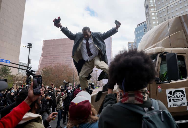 Un hombre salta de un camión que había intentado abrirse paso entre la multitud mientras la gente reaccionaba después de que se leyó el veredicto en el juicio de Derek Chauvin, el 20 de abril de 2021 en Minneapolis, Minnesota, EE.UU.