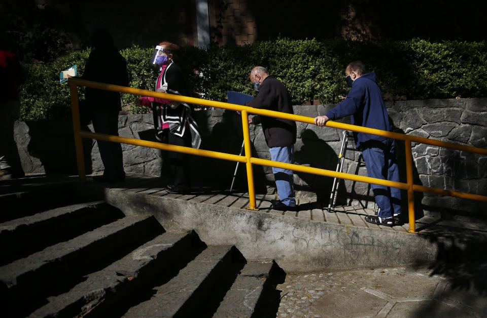 Elderly people wait to get the AstraZeneca vaccine against COVID-19 in the Magdalena Contreras area of Mexico City, Monday, Feb. 15, 2021, as Mexico begins to vaccinate people over age 60 against the new coronavirus. (AP Photo/Marco Ugarte)