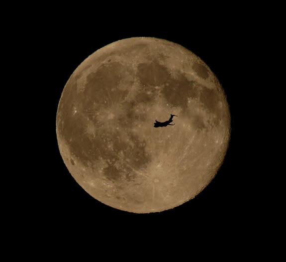 An airplane flies in front of the “blue moon” full moon of July 31, 2015 in this photo captured by skywatcher Chris Jankowski of Erie, Pennsylvania.