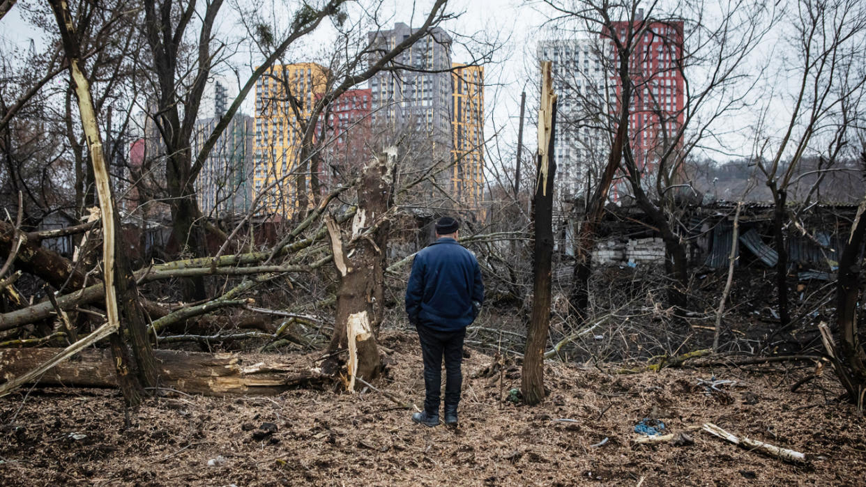 A man stands amid the damage after a morning missile strike in Kyiv.