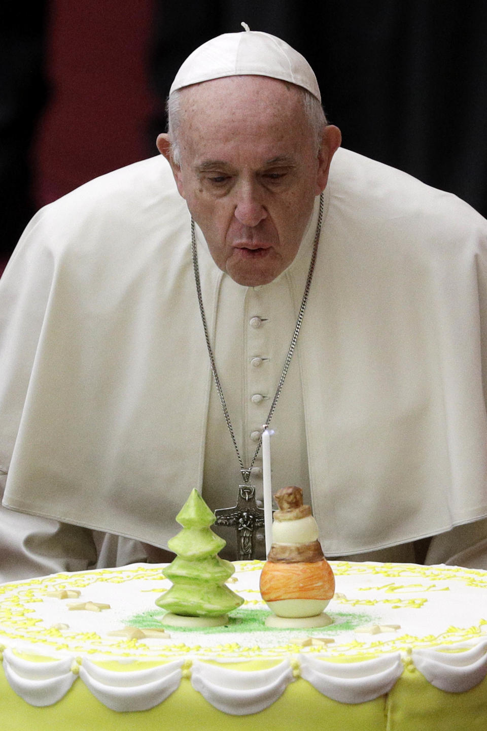 Pope Francis blows a candle atop of a cake he was offered on the eve of his 82nd birthday during audience with children and family from the dispensary of Santa Marta, a Vatican charity that offers special help to mothers and children in need, in the Paul VI hall at the Vatican, Sunday, Dec. 16, 2018. (AP Photo/Gregorio Borgia)