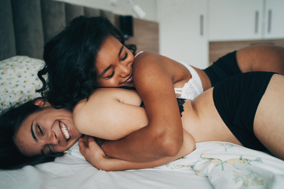 Two women embracing in bed - dating trends survey (Getty Images)