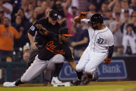Detroit Tigers third baseman Jeimer Candelario beats the tag of Baltimore Orioles third baseman Maikel Franco (3) to advance on a wild pitch during the eighth inning of a baseball game, Friday, July 30, 2021, in Detroit. (AP Photo/Carlos Osorio)