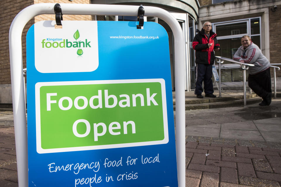 Swinging A-frame sign outside the Trussell Trust&#39;s Kingston Foodbank, Kingston, United Kingdom. The sign directs people to the foodbank which provides emergency food to local people. Two men are waiting outside the foodbank to receive their free food box which will contain basic non-perishable food for three days. In 2012-13 foodbanks fed 346,992 people nationwide. Of those helped, 126,889 were children. This form is used by a Trussell volunteer when preparing a food box for an adult. In resp (Photo by In Pictures Ltd./Corbis via Getty Images)