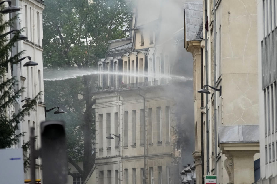 Firemen use a water canon as they fight a blaze Wednesday, June 21, 2023 in Paris. Firefighters fought a blaze on Paris' Left Bank that is sent smoke soaring over the domed Pantheon monument and prompted evacuation of buildings in the neighborhood, police said. Local media cited witnesses describing a large explosion preceding the fire, and saying that part of a building collapsed. (AP Photo/Christophe Ena)