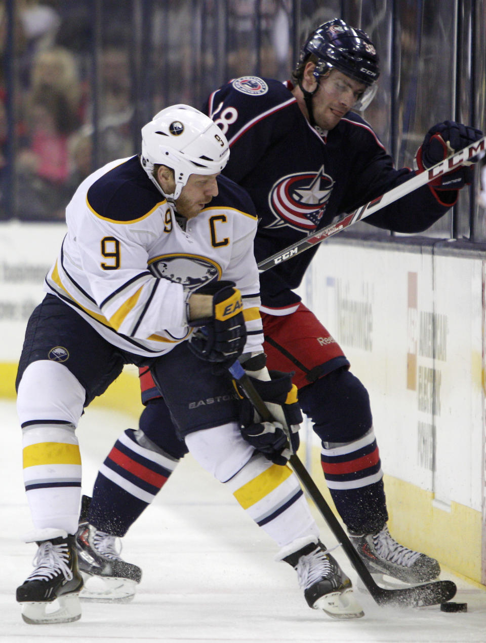 Buffalo Sabres' Steve Ott, left, and Columbus Blue Jackets' Boone Jenner fight for a loose puck during the first period of an NHL hockey game, Saturday, Jan. 25, 2014, in Columbus, Ohio. (AP Photo/Jay LaPrete)