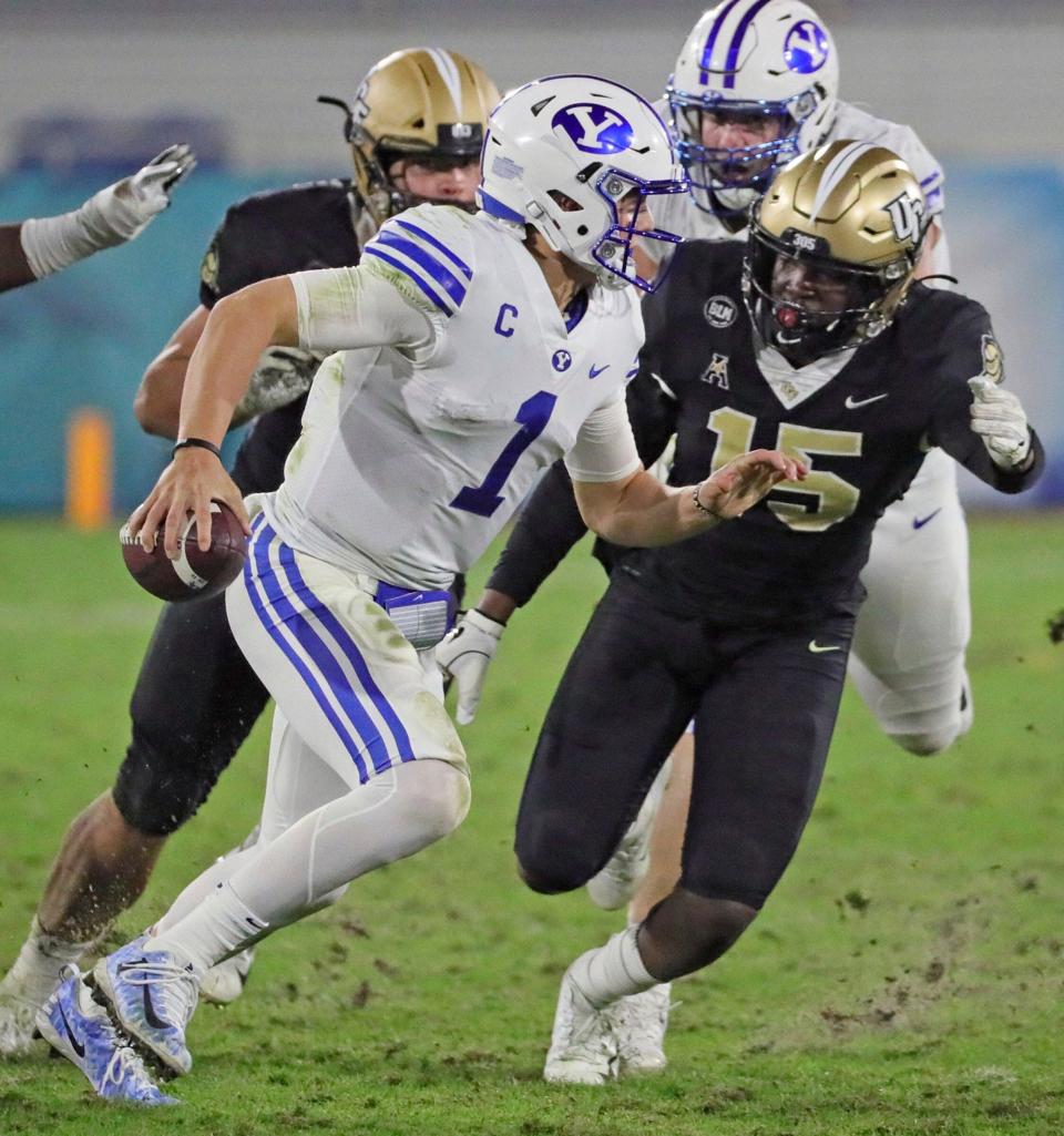 UCF linebacker Tatum Bethune (15) chases BYU quarterback Zach Wilson (1) in the fourth quarter in the Boca Raton Bowl NCAA college football game at FAU Stadium in Boca Raton, Fla. Tuesday, Dec. 22, 2020.(Al Diaz/Miami Herald via AP)