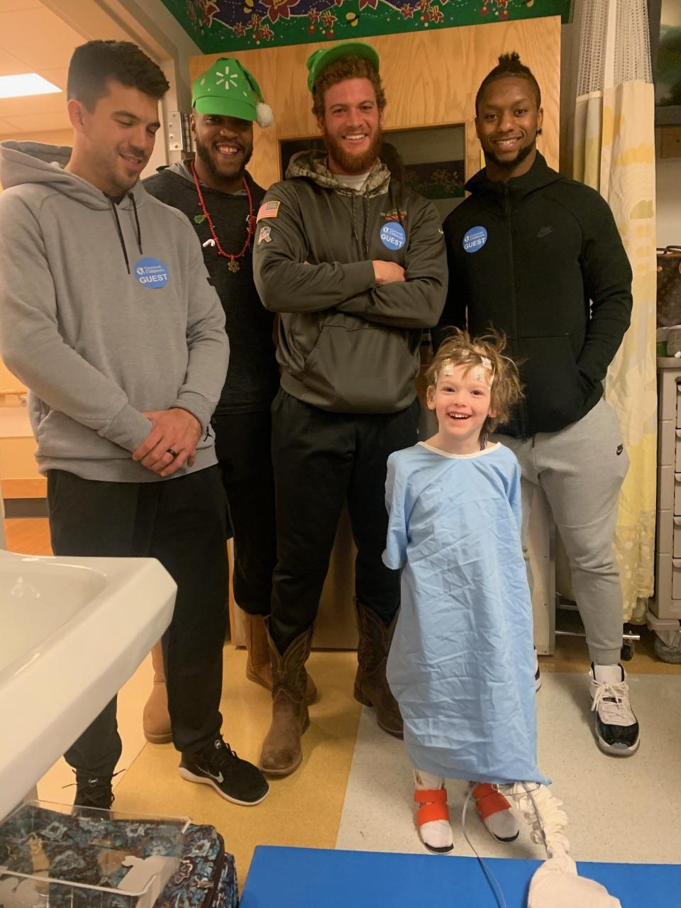 A December 2019 picture of Ephraim Lober at Cincinnati Children's Hospital Medical Center for an electroencephalogram (EEG) brain activity scan. Ephraim, then 6, is posing with players from the Cincinnati Bengals, who were making a Christmas-time visit to patients that day