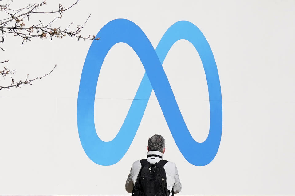 FILE - A person stands in front of a Meta sign outside of the company's headquarters in Menlo Park, Calif., March 7, 2023. Meta releases results on Thursday, Feb. 1, 2024. (AP Photo/Jeff Chiu, File)