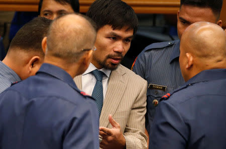 Filipino boxer and Senator Manny Pacquiao talks to Philippine National Police chief Director-General Ronald dela Rosa (back at the camera) and other police officers during a Senate hearing on crackdown on illegal drugs in Pasay, Metro Manila, Philippines August 23, 2016. REUTERS/Erik De Castro