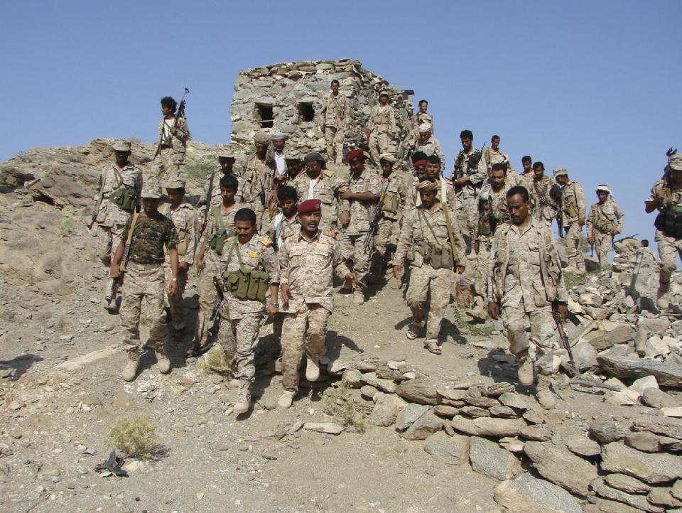 In this photo provided by the Yemen Ministry of Defense, Yemeni troops gather as they take positions at the frontline of fighting with al-Qaida militants in the southeastern province of Shabwa, Yemen, Tuesday, May 6, 2014. Yemeni troops seized two al-Qaida strongholds in the country's south after a days-long offensive that left dozens of suspected militants and troops dead, the country's Defense Ministry said Tuesday. (AP Photo/Yemen's Defense Ministry)