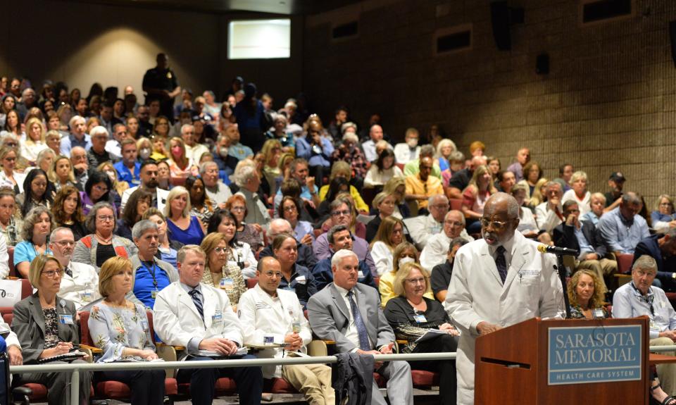 Dr. Washington Hill, former Chairman of the Department of Obstetrics and Gynecology and Director of Maternal-Fetal Medicine at Sarasota Memorial Hospital, speaks in front of a packed auditorium during the public comment portion of the Sarasota Hospital Board meeting on Tuesday, Feb. 21, 2023.