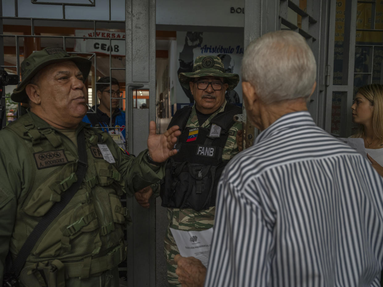 Miembros de una milicia leal al gobierno del presidente Nicolás Maduro en la entrada de un centro de votación en un barrio donde la oposición no tenía observadores electorales en Caracas, la capital de Venezuela. (Alejandro Cegarra/The New York Times)
