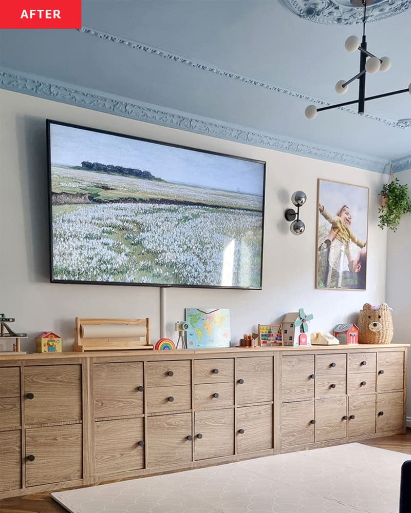 Toy storage cabinets below a large tv in a white living room.