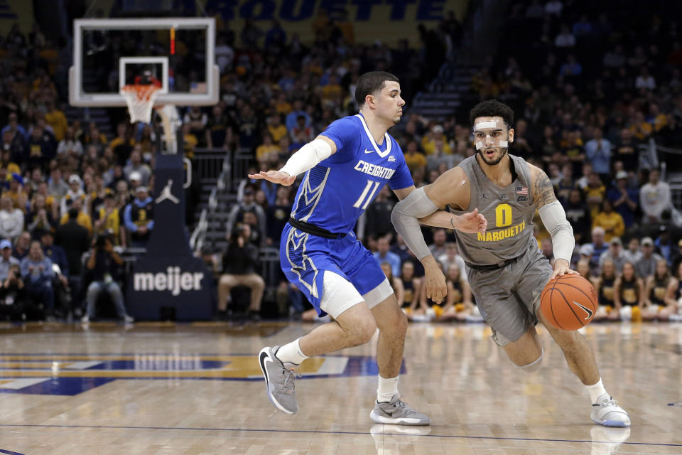 Marquette's Markus Howard (0) drives to the basket against Creighton's Marcus Zegarowski (11) during the first half of an NCAA college basketball game Tuesday, Feb. 18, 2020, in Milwaukee. (AP Photo/Aaron Gash)