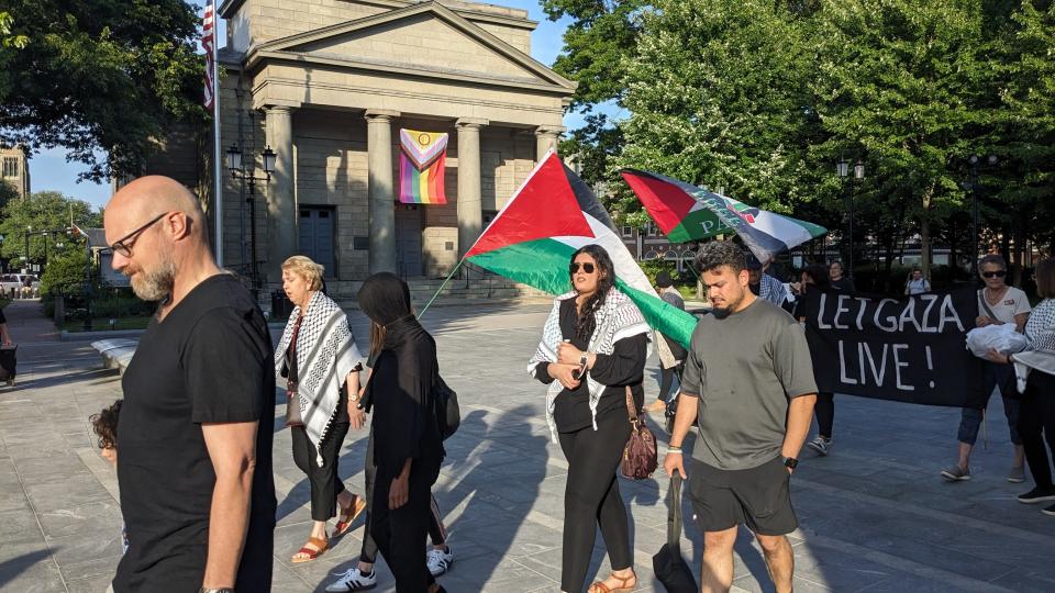 Members of Quincy for a Free Palestine march through Quincy Square during a vigil for Palestinian victims of Israeli military operations in Gaza.