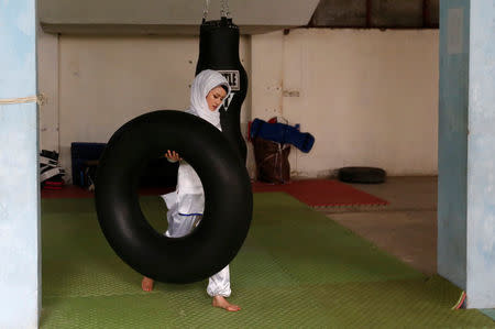 Sabera Bayanne, 20, a student at the Shaolin Wushu club, carries a tube before an exercise in Kabul, Afghanistan January 29, 2017. REUTERS/Mohammad Ismail