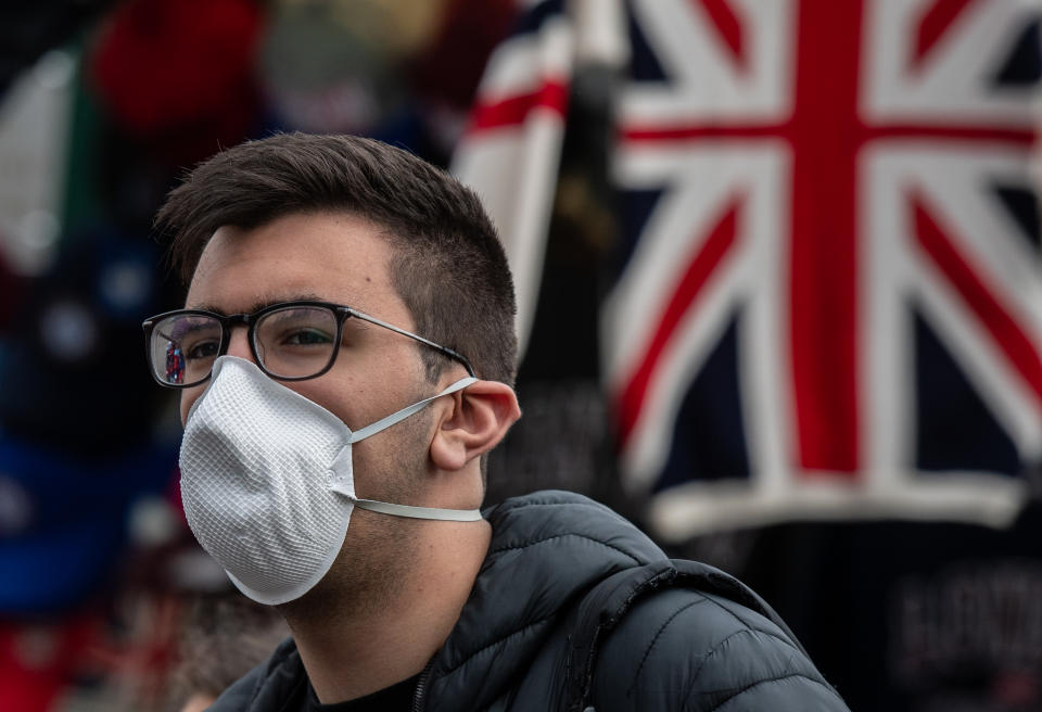 LONDON, ENGLAND - MARCH 14: A tourist wears a face mask next to a souvenir stall on Westminster Bridge as the outbreak of coronavirus intensifies on March 14, 2020 in London, England. Many Londoners and tourists are continuing they daily activities whilst mass gatherings could be banned in the UK from as early as next weekend as the outbreak of coronavirus intensifies. Many nations in Europe have already introduced strict travel bans and limits on their citizens daily lives whilst the United States has suspended incoming travel from European countries. (Photo by Chris J Ratcliffe/Getty Images)